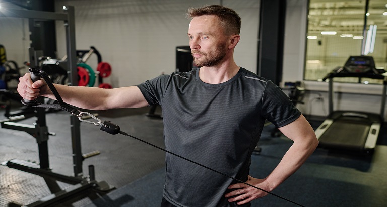 Lifter performing a cable lateral raise at a low pulley
