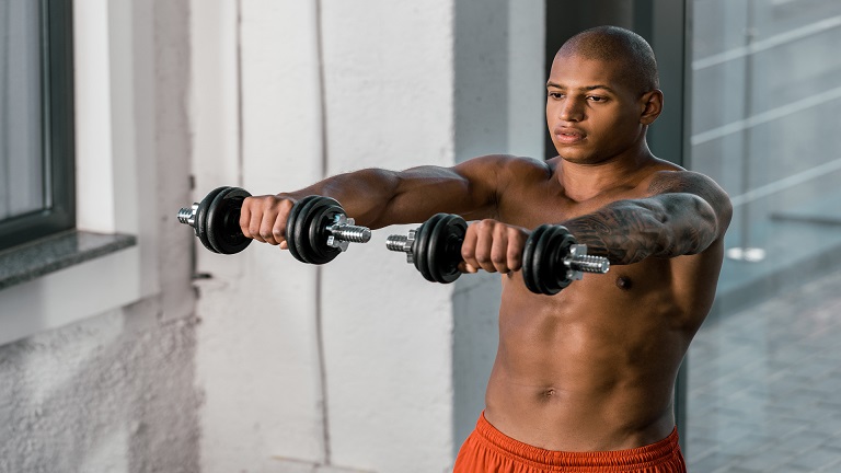Muscular lifter performing a dumbbell front raise showing start and top positions