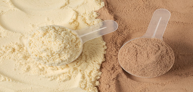 Casein and whey protein powder scoops side by side